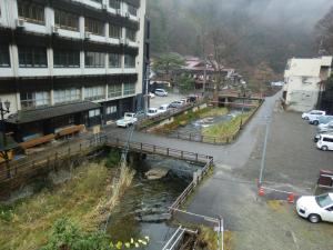 una calle de la ciudad con coches estacionados al lado de un edificio en Motoyu Arimaya, en Aizuwakamatsu