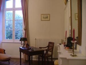 a living room with a table and a window at Chambres d'Hôtes Launay Guibert in Miniac-Morvan