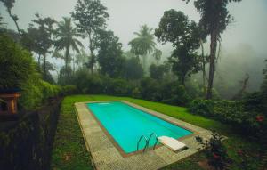 a swimming pool in the yard of a house at After the Rains - Rainforest Lodge in Meppādi