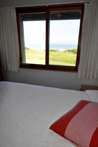 a bedroom with a bed and a window with the ocean at 14 Steps in Marengo