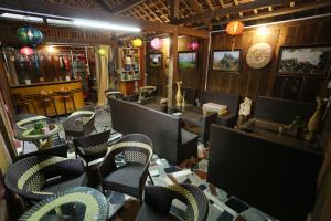 a restaurant with chairs and tables and a bar at Green Hill Hostel & Tour in Ha Giang