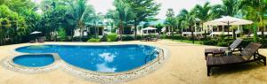 - une piscine dans un complexe avec 2 chaises et un parasol dans l'établissement N.T. Lanta Resort, à Ko Lanta