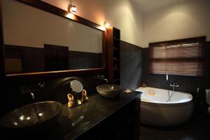 Un baño con dos lavabos y una bañera. en Villa Bunga Melati, en Banjar