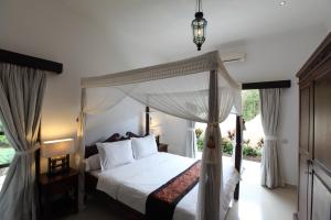 un dormitorio con una cama con dosel en Villa Bunga Melati, en Banjar
