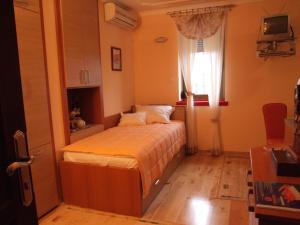 a small bedroom with a bed and a window at Hotel Tehnograd in Kraljevo