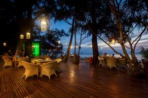 a patio with tables and chairs and umbrellas at Bamboo Bungalows in Ko Phayam