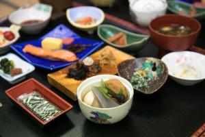 una mesa cubierta con tazones y platos de comida en Kanouya, en Omachi