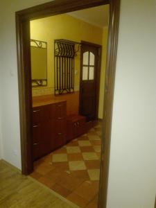 La salle de bains est pourvue d'un miroir, d'un lavabo et d'une porte. dans l'établissement Apartament Śródmieście, à Łańcut