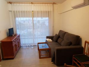 sala de estar con sofá y TV en Apartamentos Olympia Center, en La Manga del Mar Menor