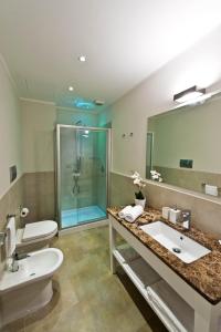 a bathroom with a sink and a toilet and a mirror at Delle Vittorie Luxury Rooms&Suites in Palermo