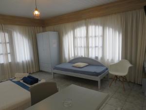 a bedroom with a bed and a table and chairs at Blue Beach Villas Apartments in Stavros