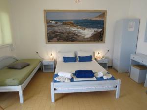 Blue Beach Villas Apartments في ستافروس: غرفة نوم بسرير ودهان على الحائط