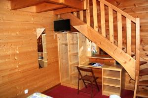 eine Holzhütte mit einem Schreibtisch und einer Treppe in der Unterkunft Hotel Restaurant Home Des Hautes Vosges in La Bresse