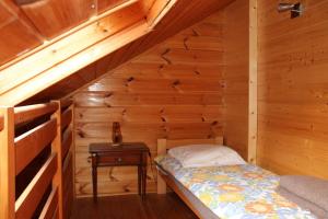 Cama pequeña en habitación de madera con mesa en Hotel Restaurant Home Des Hautes Vosges, en La Bresse