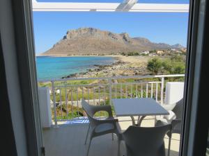 a balcony with a table and chairs and a view of the beach at Blue Beach Villas Apartments in Stavros