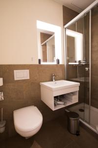 
a bathroom with a toilet, sink and mirror at Kreuz Bern Modern City Hotel in Bern
