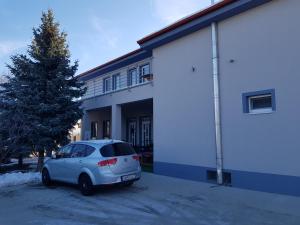 a white car parked in front of a building at Ubytovanie House in Galanta