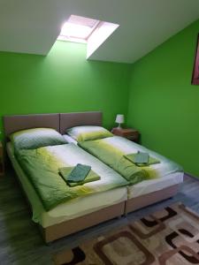 - une chambre avec un grand lit aux murs verts dans l'établissement Ubytovanie House, à Galanta