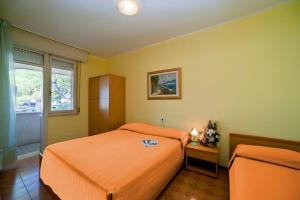 a bedroom with an orange bed and a window at Olimpia in Bibione +8 photos