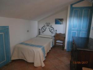 a bedroom with a bed and a dresser and a door at Casa Gallo in Santa Marinella