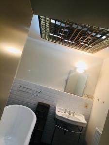 Un baño con lavabo, inodoro y espejo. en Kirisavan Bed&Breakfast, en Borgloon 35 fotos más