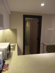 a kitchen with a microwave and a door to a bathroom at Best Studio Guest House in Kota Bharu