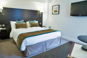 a bedroom with a large bed and a flat screen tv at The Beaumont Hexham in Hexham