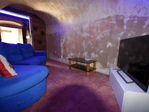 un salon avec un canapé bleu et une télévision dans l'établissement Belvilla by OYO Casa dei Nonni, à Provaglio d'Iseo