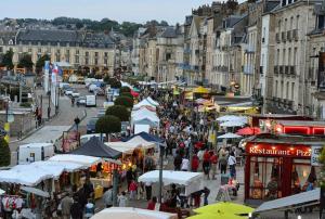 a crowd of people walking around a market with umbrellas at Le studio d'Evelyne in Dieppe