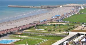 a crowd of people on a beach with a pier at Le studio d'Evelyne in Dieppe +2 photos