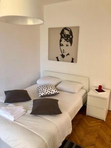 1 dormitorio con 1 cama blanca grande con una foto en la pared en Studio Confort, en Bucarest