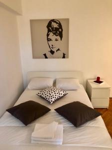1 cama con 2 almohadas y una foto en la pared en Studio Confort, en Bucarest 18 fotos más