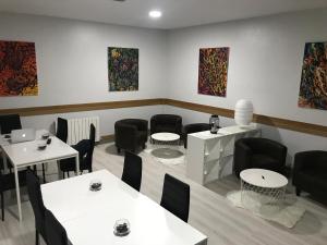 Habitación con mesas, sillas y pinturas en la pared. en Pensión La Salve, en Bilbao