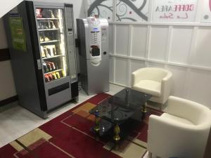 uma sala com uma máquina de venda automática, uma mesa e cadeiras em Pensión La Salve em Bilbau