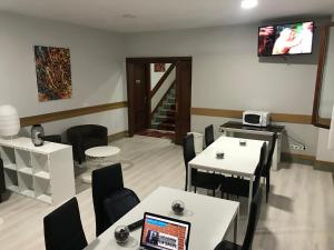 a dining room with tables and chairs and a laptop at Pensión La Salve in Bilbao