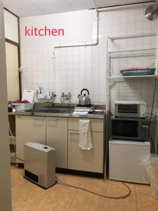 a kitchen with a sink and a microwave at Kenroku Haitsu 101 in Kanazawa