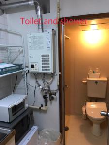 a bathroom with a toilet and a microwave at Kenroku Haitsu 101 in Kanazawa