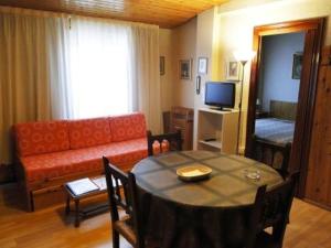 sala de estar con mesa y sofá en Apartamentos Meritxell Sherpa, en Pas de la Casa