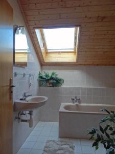 La salle de bains est pourvue d'un lavabo, d'une baignoire et d'une fenêtre. dans l'établissement Pension Arnika, à Deštné v Orlických horách