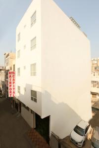 a white building with a car parked next to it at Hotel Chanakya inn in New Delhi