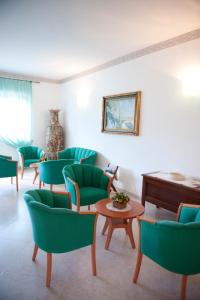 ヴィエステにあるOasiclub Hotel - Appartamentiの緑の椅子とテーブルが備わる待合室