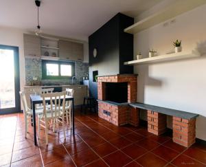 ランダッツォにあるla casa della querciaのキッチン(暖炉、テーブル、椅子付)