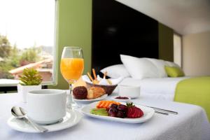 una mesa de desayuno con una copa de zumo de naranja y fruta en Casa Hotel Achumani, en La Paz