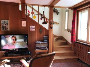 a living room with a television and a staircase at Cesa Marcella in Ortisei