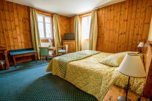 a hotel room with a bed and a table at Lautaret Lodge & Spa in Le Monêtier-les-Bains