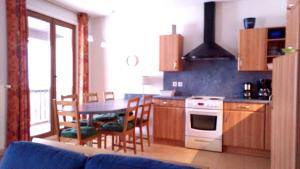 eine Küche mit einem Tisch und einem Herd Top-Backofen in der Unterkunft Appartement la Charbonnière in Bellefosse