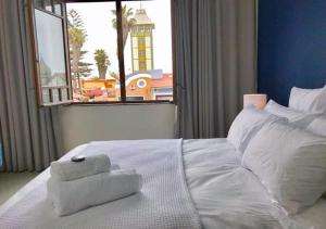 a white bed with a towel on it in front of a window at Bismarck 2 in Swakopmund