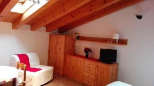 ein Schlafzimmer mit einem Bett und einem TV in einem Zimmer in der Unterkunft Sweet Home Casa Vacanze "La Mansarda" in Rovetta