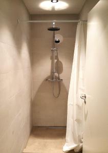 um chuveiro na casa de banho com uma cortina de chuveiro em Lækur Hostel em Reykjavík