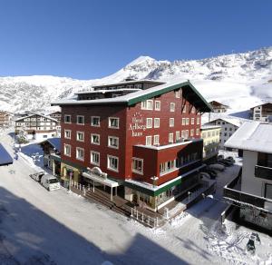 ein großes Gebäude inmitten eines schneebedeckten Berges in der Unterkunft Arlberghaus in Zürs am Arlberg